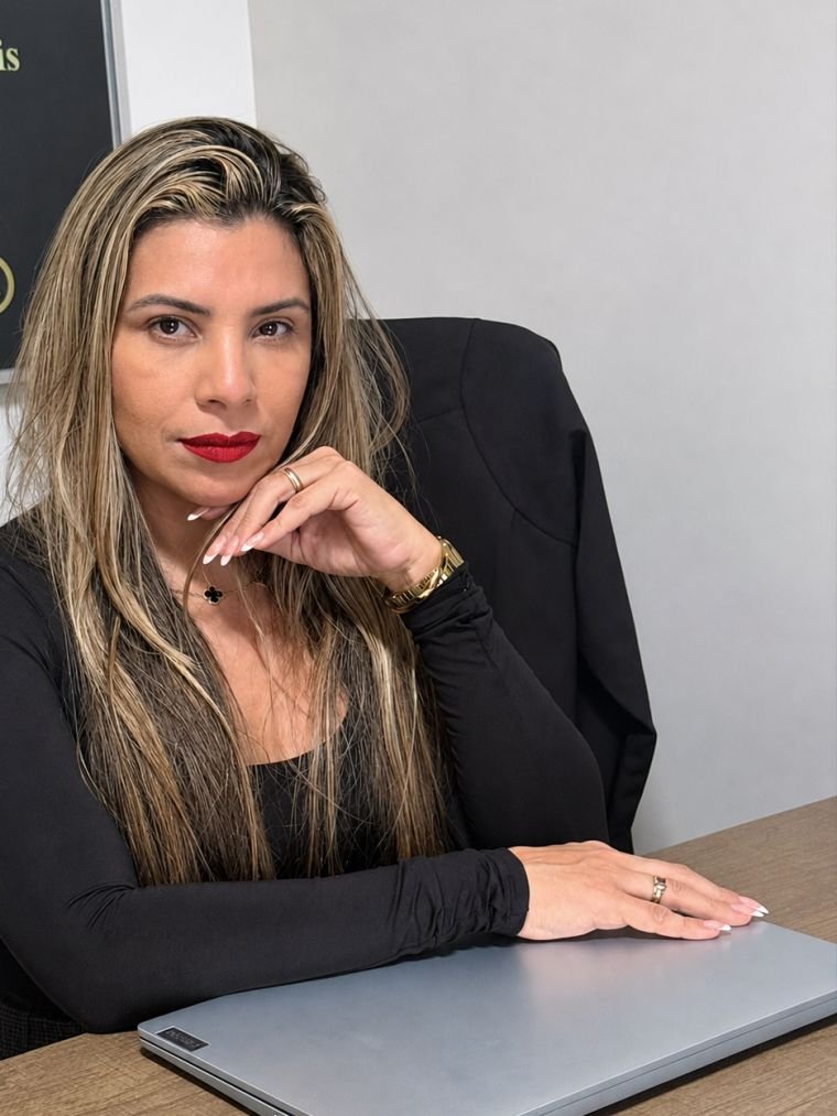 A advogada Aline Silva de Macêdo em sua mesa de trabalho no escritório
